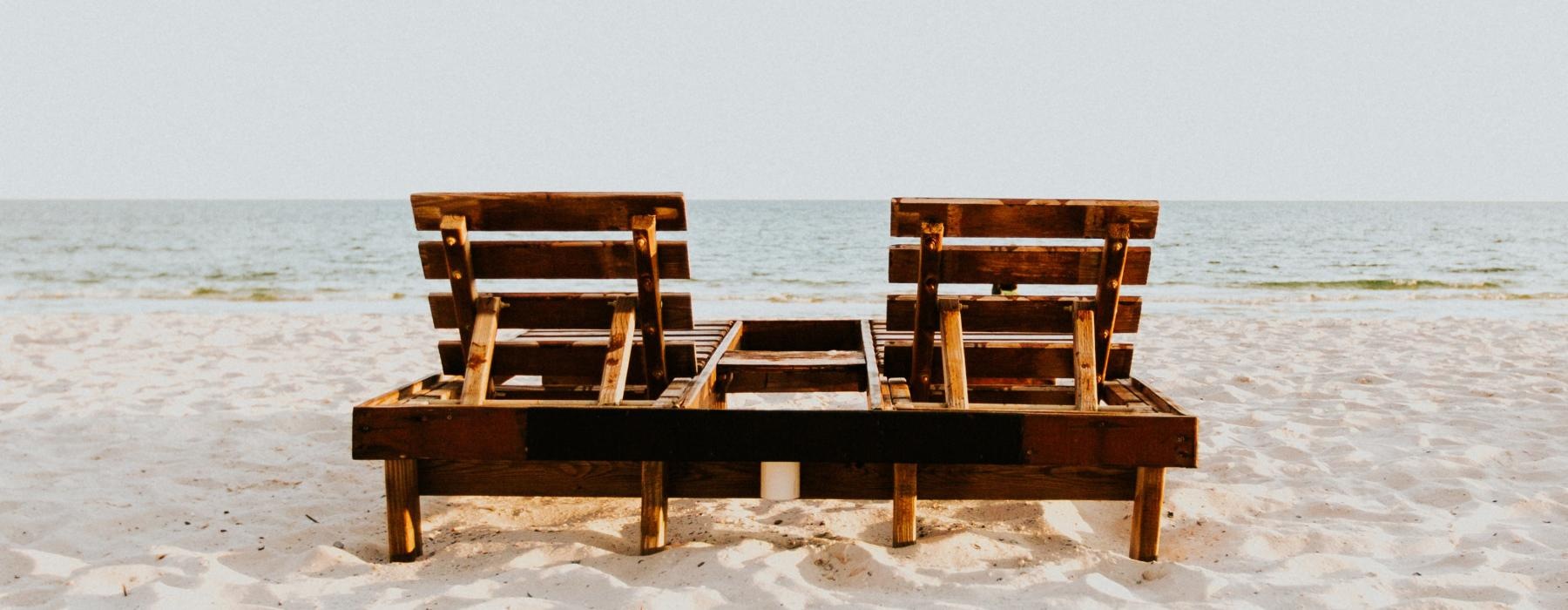 a couple of benches sit on a beach