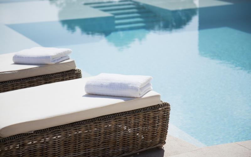 a basket with a towel and a basket by a pool