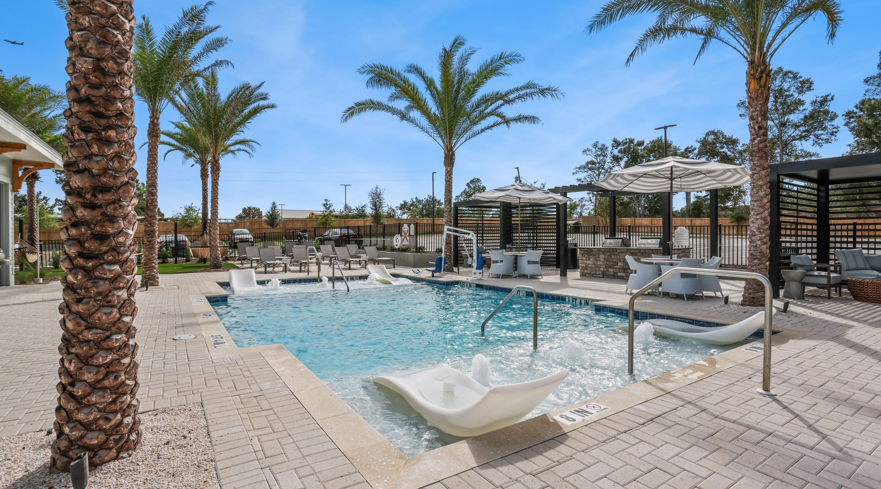 Pensacola, FL Apartments With In-Unit Washer And Dryer - Casara Pensacola - A Pool With In-Water Loungers, Palm Trees, Stylish Cabanas, Shaded Lounges, And Bubbling Water Jets.